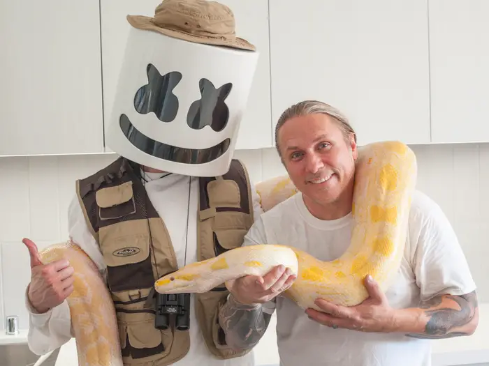Brian holding a python with renowned music producer Marshmellow