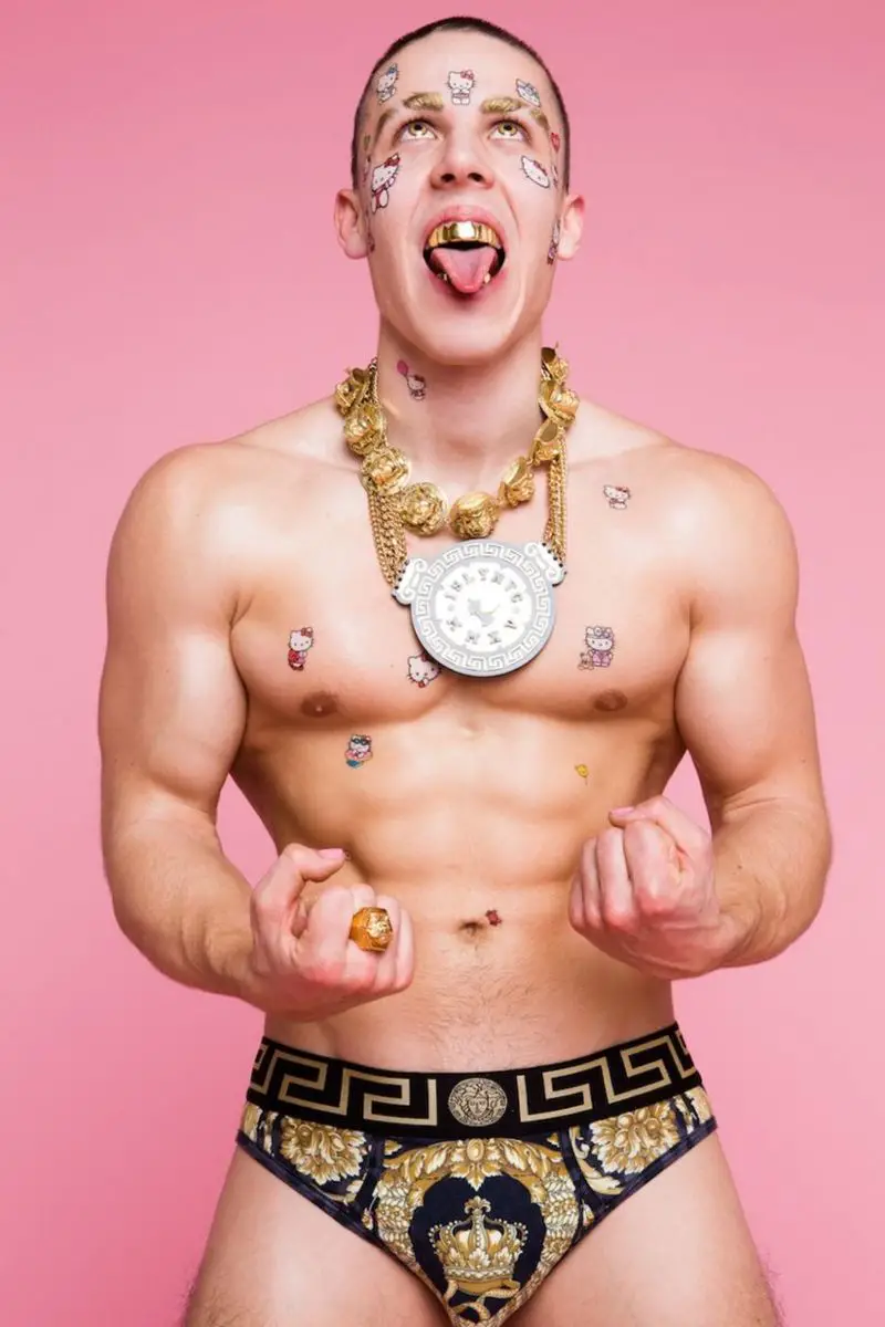 Candy Ken posing with his pieces of jewelry and Versace garment