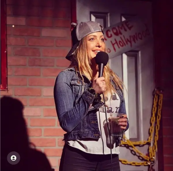 Kate Quigley while performing on the stage of Haha Comedy Club