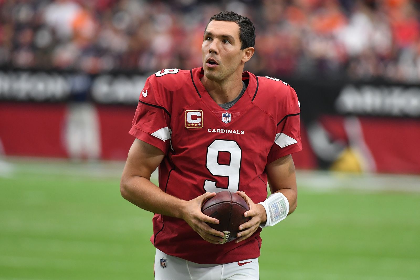 Sam Bradford holding the ball in Cardinals jersey, on-field of NFL